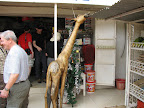 Stopping at a quick mart - wooden giraffe licks roofing.