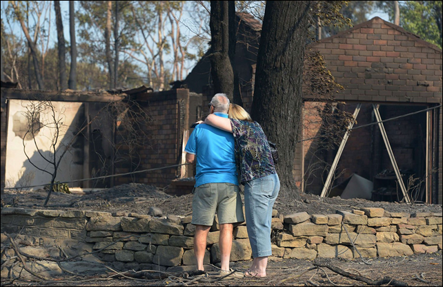 A couple look at their house burnt out by bushfires in Winmalee in Sydney's Blue Mountains, on 18 October 2013. Photo: Greg Wood / AFP / Getty Images
