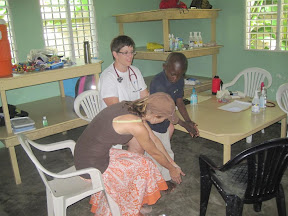 Julian our trnaslator showing Luis how to bend over for his scoliosis check