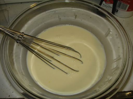 Whisk together egg yolks, milk, and cream before adding to the dry ingredients in the saucepan.