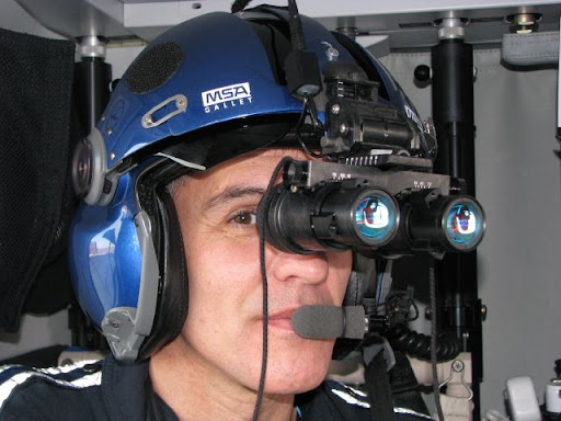 Flight nurse Jim Lawrence demonstrates how the night vision goggles fit onto the helmets already worn by the flight crew during flight.