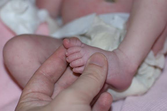 The tinyness of her toes is crazy... particularly the pinky.  This shows the difference between my thumb and her toes.