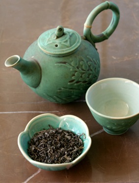 green tea with teapot and tea leaves