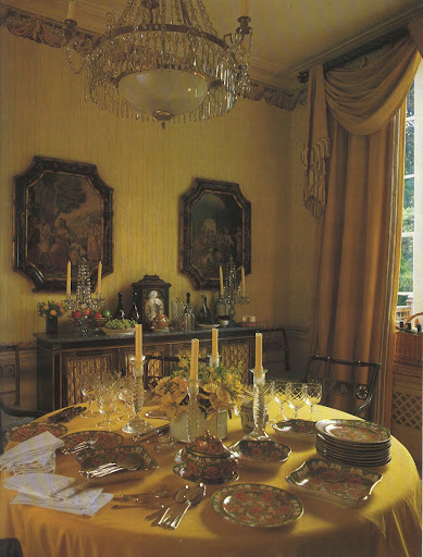 Love the combination of French caste (pair of pictures and chandelier), Regency-style dining room, and swagged neo-Classical curtains all in deep, rich colors.