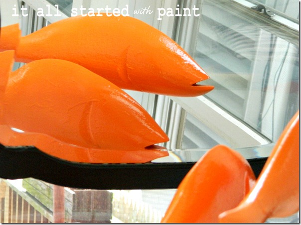 fish_wooden_on_sticks_painted_bright_orange
