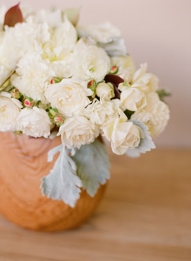This sweet floral arrangement sits in a wood bowl. It's a great way to tie in the natural materials of the cake stand. This sweet floral arrangement sits in a wood bowl. It's a great way to tie in the natural materials of the cake stand.