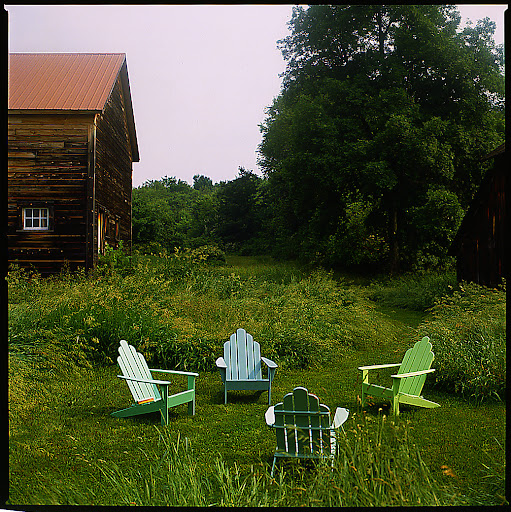 A: Adirondack chairs painted in pastel colors blend into any yard setting. Grouping the chairs towards each other creates a natural space for guests to chat and sip cocktails. A: Adirondack chairs painted in pastel colors blend into any yard setting. Grouping the chairs towards each other creates a natural space for guests to chat and sip cocktails.