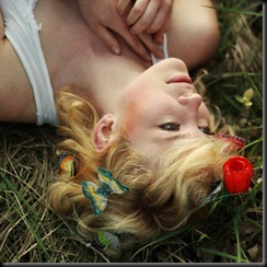 A mulher deitada na grama com Borboletas e Flor_