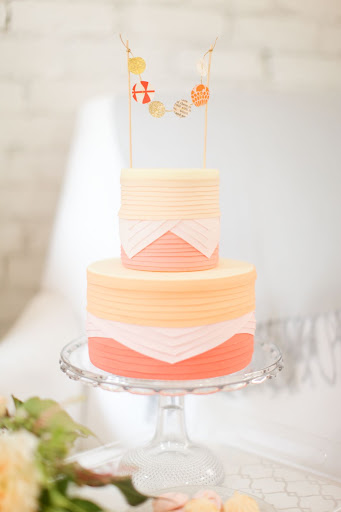 A pleated cake is topped with a small garland of its own.