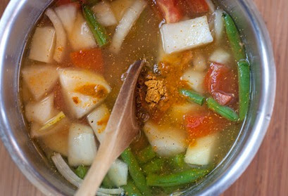 Adding sambar powder: Cardamom Kitchen Adding sambar powder to vegetables and lentils before they are simmered