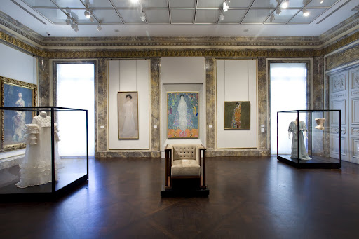 Famous paintings by Gustav Klimt hang on the marble and gilded walls.