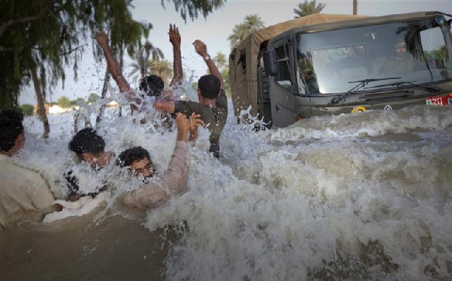 Evacuees from a flooded village dodge an army truck carrying relief supplies in Pakistan’s Punjab province on 11 August 2010. Adrees Latif via Ethiopian Review