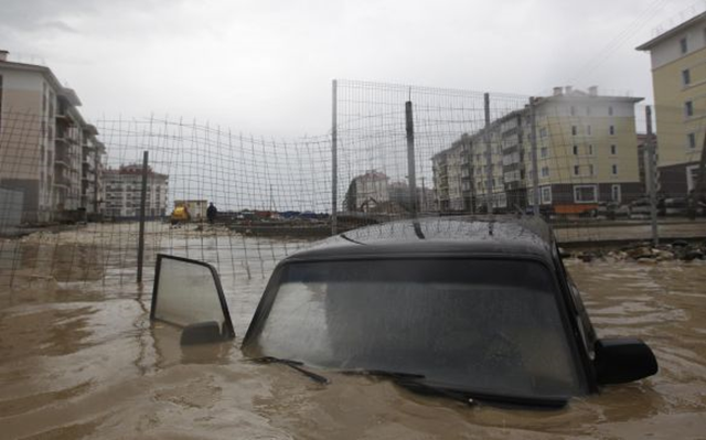 A stranded vehicle drifting in floodwaters in Sochi, where a state of emergency has been declared by authorities after days of rain and mudslides, 26 September 2013. Photo: Maxim Shemetov / Reuters