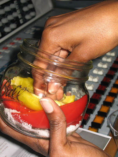 Under Sandy's instruction, Shavon began loading her jar with sugar, garlic, and two types of bell peppers.