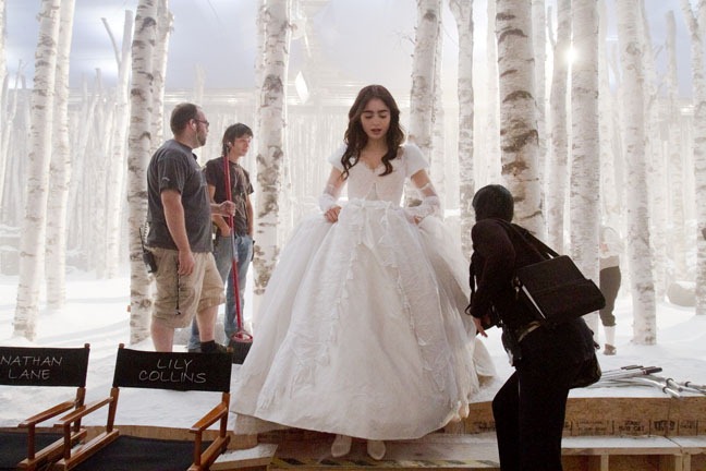 Lily Collins steps off set as snow dressers Frederic Cournoyer and Marc Chow prepare to work, "Snow White," September 13, 2011