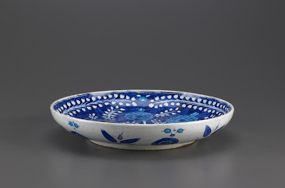 Dish | Origin:  Iznik,  Turkey | Period: 1530s  Ottoman period | Details:  This plate is representative of one type of underglaze-painted ceramic produced in Iznik during the sixteenth century. The earliest type was blue-and-white ware decorated in the center with floral scrolls and on the rim with wave and foam patterns. Such motifs emulate designs on Chinese porcelains, which had become extremely popular at the Ottoman court. By mid-century, the palette of Iznik ceramics had expanded to include turquoise, green, purple, and a unique tomato red. The decorative repertoire also grew, and recognizable species of flora and fauna were commonly depicted. | Type: Stone-paste painted under glaze | Size: H: 5.8  W: 18.8   D: 31.2  cm | Museum Code: F1963.7 | Photograph and description taken from Freer and the Sackler (Smithsonian) Museums.