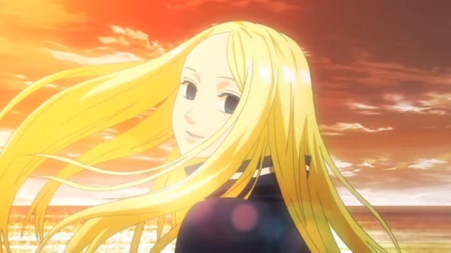 Nino turning around to look behind her, smiling, her long blonde hair flowing in the wind
