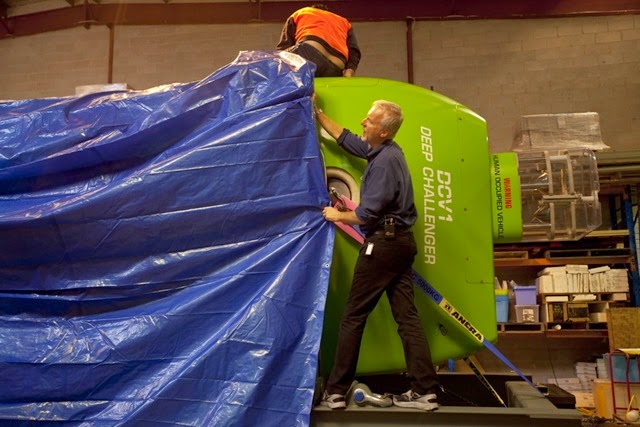 James Cameron pulling a tarp off the submersible at the Acheron Project offices in Sydney Australia