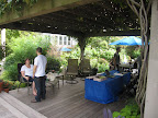 The deck has a pergola with lush grapevines covering the top. Here, Rick and his crew and putting the finishing touches on the space before the guests arrive.