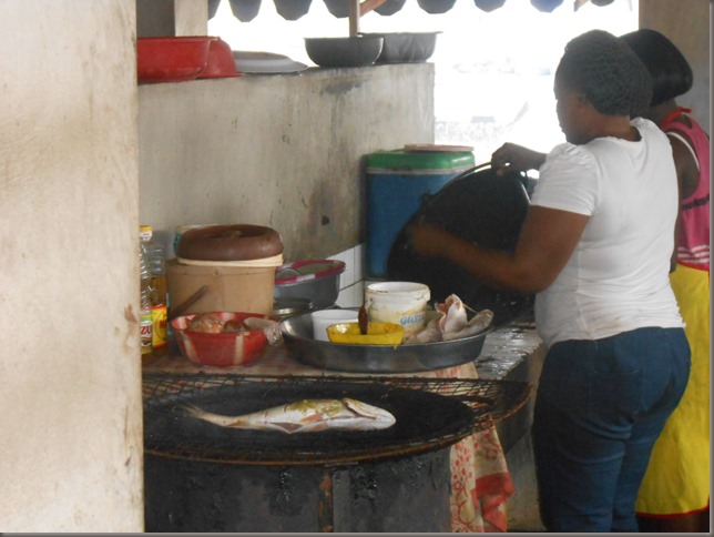 Lady cooking fish in restaurant