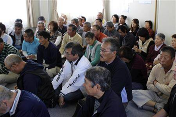 Evacuees who fled from Namie town near the tsunami-crippled Fukushima Daiichi nuclear power plant listen to government officials' explanations about how to apply for compensation at their temporary housing complex in Fukushima on 6 October 2011. Staff  /  REUTERS