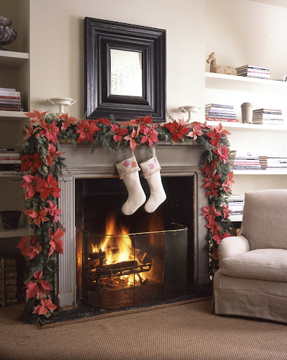 A fireplace seems even warmer when draped in a garland of blue atlas cedar and seeded eucalyptus boughs, which are puncutated with five varieties of pink and red poinsettias. A fireplace seems even warmer when draped in a garland of blue atlas cedar and seeded eucalyptus boughs, which are puncutated with five varieties of pink and red poinsettias.