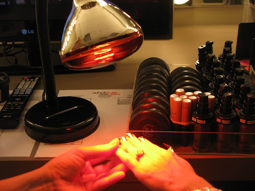Here the manicurist is sealing the foil.