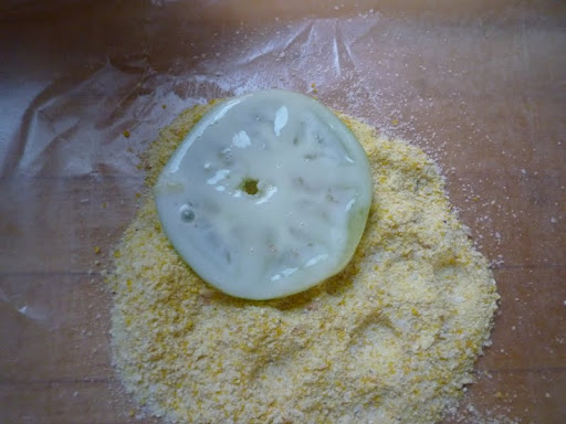 After a soak in buttermilk, the tomato slices get coated in cornmeal.