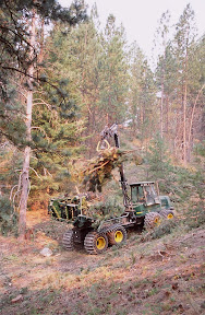 The Dirty Hands People - This Timberjack bundler is working on private forestland near Missoula, Montana. The bundles it assembles from trees and brush are headed for a nearby pulp mill that will burn them in their power plant. The slight orange tinge in this photograph is the result of sunlight filtering through a smoke-filled sky. The smoke was coming from one of western Montana's all too common forest fires - fires that will continue to burn with increasing ferocity until the Congress musters the political will to fund thinning and standing projects on physical scales large enough reverse the ecological collapse that has enveloped the region's overstocked and dying national forests.