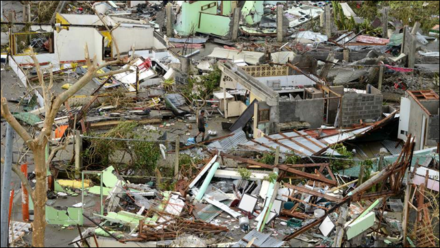 In the wake of Suprt Typhoon Haiyan, a man walks amid shattered homes in Tacloban, 9 November 2013.  Photo: Sky News