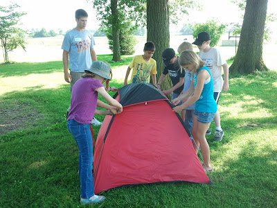 Campers put the finishing touches on a tent they put together as a team while County Council Matt Romoser supervises.  Photo courtesy of the Washington County Extension.