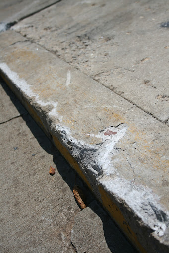 The fallen pole also damaged the sidewalk. (photo credit: James Mulvenon)