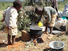 Victor Muruga (r) and his three-year-old brother Ian Kimani (l) prepare lunch from their camp at  Mumoi farm. Peter Kahare / IPS