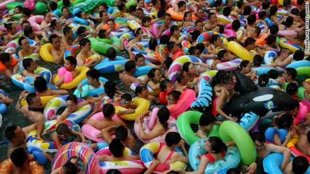 Mass crowds of people attempt to cool off at a water park in Suining, Sichuan province on Saturday, 27 July 2013 amid a record heat wave hitting 19 provinces and regions in China. People are packing into swimming pools or taking refuge in caves to escape the fierce temperatures. Local governments are resorting to cloud-seeding technology to try to bring rain to millions of acres of parched farmland. Photo: CNN