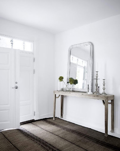 This photograph from Desire To Inspire is from the inside of a Danish home. I love how the silver accents (the frame around the mirror and the candle sticks) add an edge to the white room.