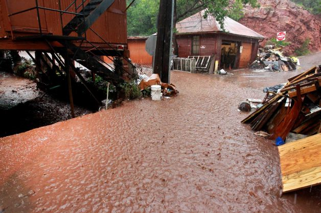 In this 12 August 2013 photo, earth-filled water from a heavy rainstorm begins to flow over a drainage creek during flooding which occurred three days after a deadly flash flood struck at the same location, causing millions of dollars in damage, in Manitou Springs, Colorado. Manitou Springs lies downstream of the vast swaths of scorched earth left behind by last year's Waldo Canyon Fire, making the town highly prone to flash flooding. In Colorado, multiple flash floods have struck this summer in or near scars left by last year's wildfires. Photo: Brennan Linsley