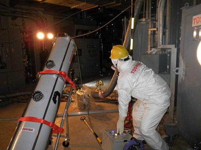 In this photo released TEPCO, a worker operates an endoscope to take photos of water in the Unit 2 reactor's primary containment vessel at the the tsunami-crippled Fukushima Dai-ichi nuclear power plant, Monday, 26 March 2012. TEPCO, the operator of the nuclear power plant, said the water level of the reactor container is only 60 centimeters (about 2 feet) from the bottom, indicating a large quantity of water injected to cool the melted fuel is leaking from the vessel. AP Photo / Tokyo Electric Power Co.