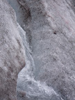 Water running down a deeper crack. Pouring loud water.