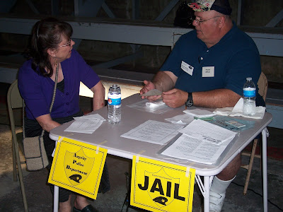 Sallie Graves (representing a person in poverty) at the simulation jail visiting with Ray Atkins (representing a police officer and illegal activities person) trying to work out a solution to her situation.  Photo courtesy of the Washington County Extension.