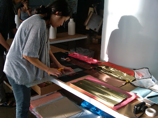 Here, Julie cuts gold fringe for the photo-booth backdrop.