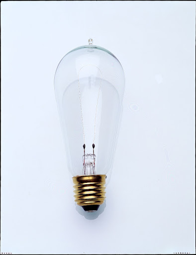 This is a reproduction of an Edison bulb. The earliest lightbulbs were hand-blown and had small nubs at the tops that were caused by the removal of glass tubes used to remove air from inside the bulbs. This is a reproduction of an Edison bulb. The earliest lightbulbs were hand-blown and had small nubs at the tops that were caused by the removal of glass tubes used to remove air from inside the bulbs.