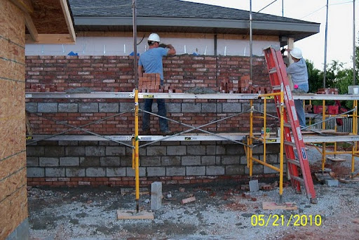 Volunteers lay brick on the outside of the Kingdom Hall. (Photo by Art Morris)
