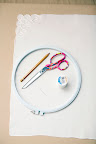 To create hand-stitched napkins, you'll need scissors, a vintage napkin, a pencil, thread, and a needle.
