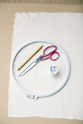 To create hand-stitched napkins, you'll need scissors, a vintage napkin, a pencil, thread, and a needle. To create hand-stitched napkins, you'll need scissors, a vintage napkin, a pencil, thread, and a needle.