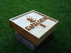 Stempel Phanos 
Materiaal: linde
Behandeling: bootlak
Afmeting: 30x30x8cm
Achtergrondinformatie: is een stempel om het bedrijfslogo te zetten in fijn zand, dat in grote bakken op een terras dient als asbak. Met handgrepen op de achterzijde. Origineel idee!