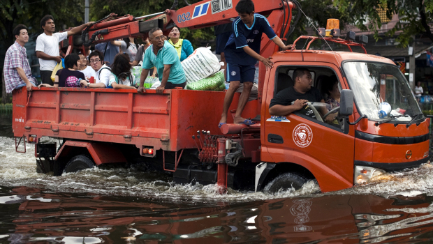 Thai residents ride on a truck through floodwaters as they evacuate their neighborhood next to the Chao Praya river in Bangkok, 28 October 2011. AFP / Getty Images