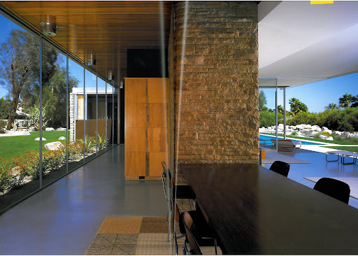 The dining room of the Kaufmann House, with Eames chairs and a Raymond Loewy-designed rug. The wall of glass to the left mimics the open wall to the right. It's an invitation to bring the outdoors in, and it inspires me to create a botanical garden on my deck.
