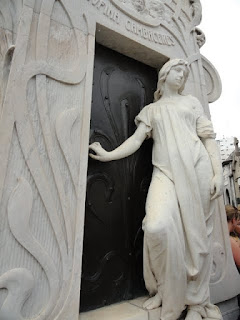 Sad story. This girl was buried after dropping into a coma. She woke up in her tomb and the workers heard her screaming. She got the coffin open but before they could open the tomb she died of a heart attack. Her grandmother erected this statue to show she almost made it out alive.