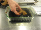 When the gingerbread men come out of the oven, he dunks each one in a molasses water bath.