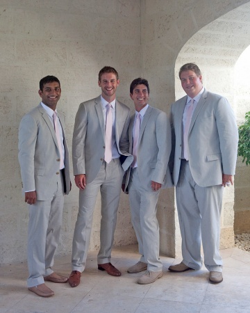 Groomsmen attending a destination wedding in Turks and Caicos looked beach-chic in light-colored suits and pink ties. Groomsmen attending a destination wedding in Turks and Caicos looked beach-chic in light-colored suits and pink ties.